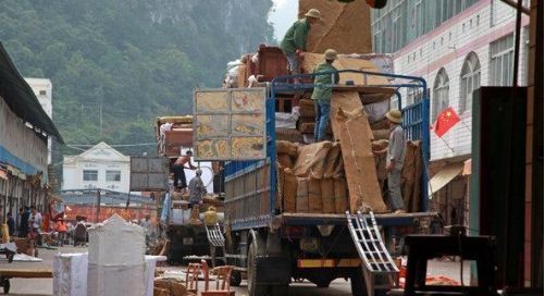 在中越边境的广西浦寨，工人们正在卸载经过半加工包装好的红木