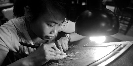 在博览中心举行的红木家具展现场，一名雕刻女工现场展示其精湛的刀法